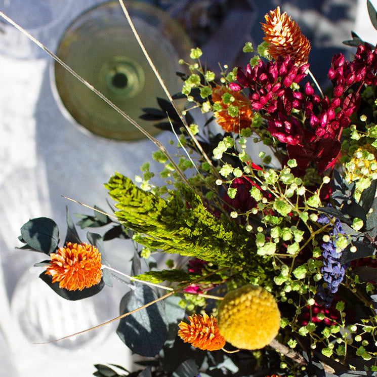 Stilfull festdukning till Midsommar sedd ovanifrån, med färgstarka blommor i buketten Blomsterglädje
