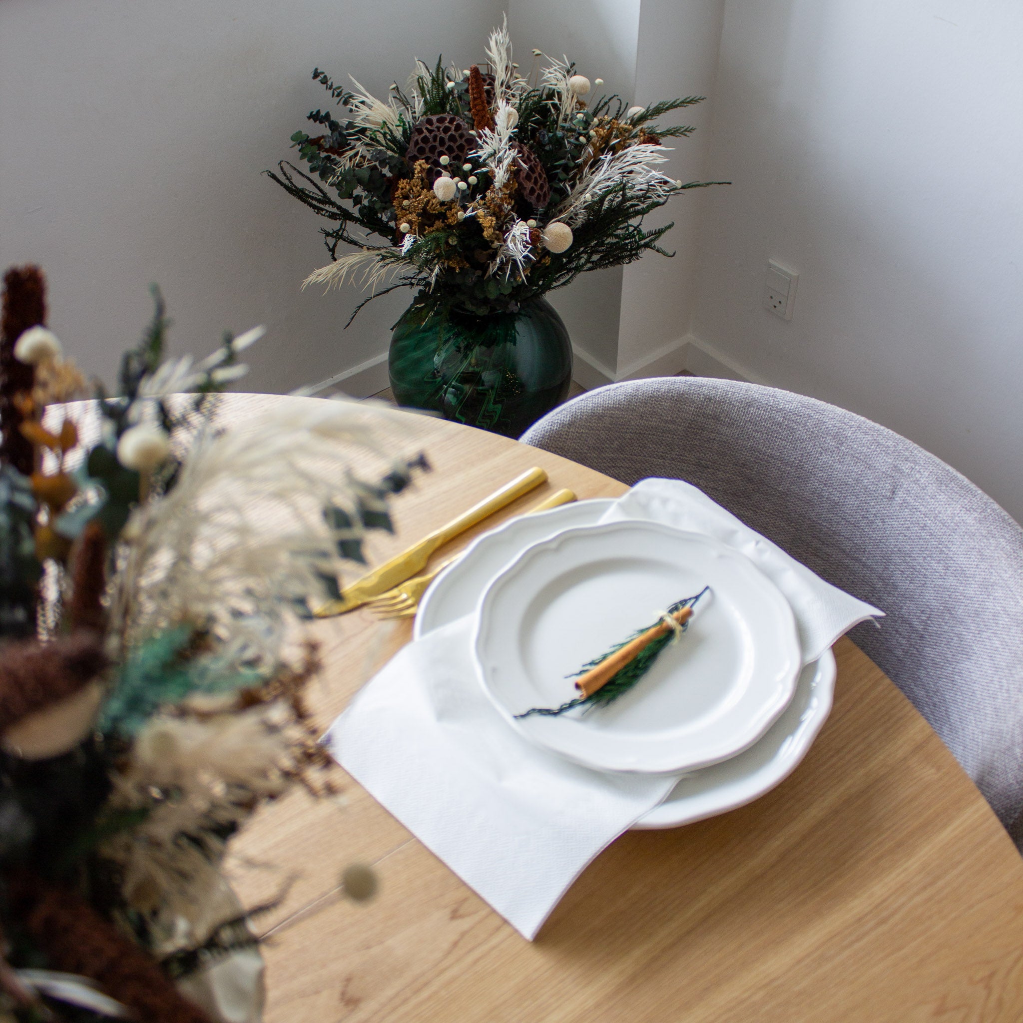 Vacker, minimalistisk juldukning med blombuketter i vitt och brunt.