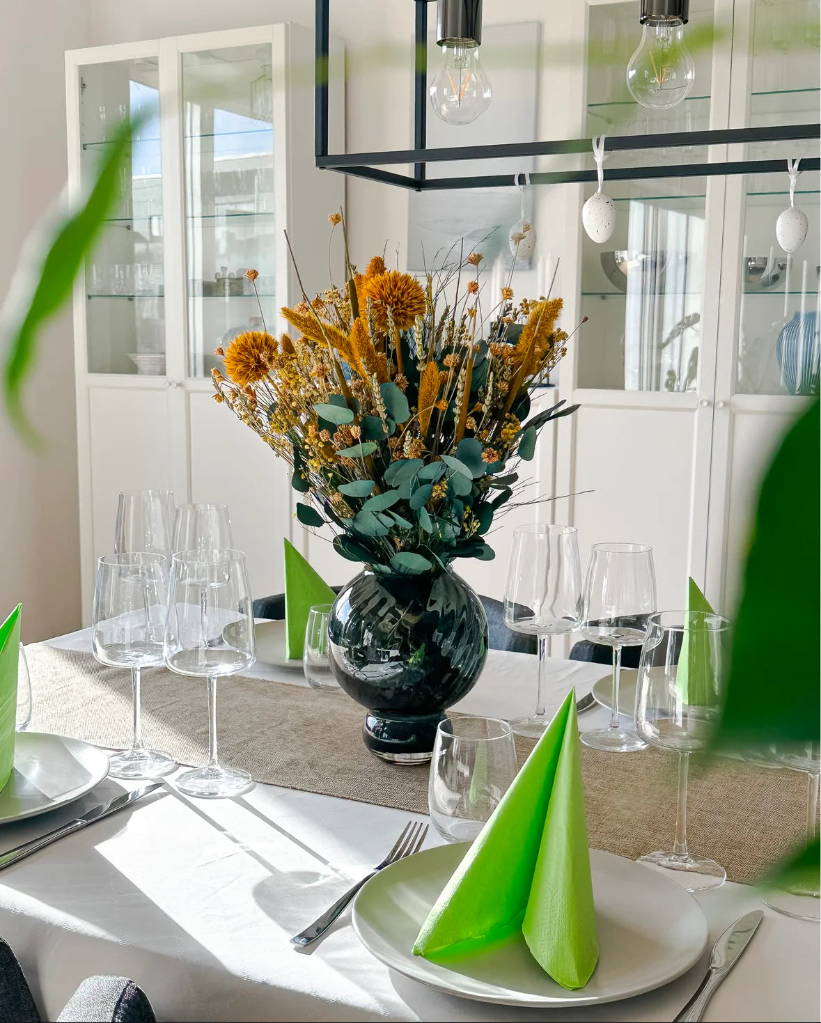 En orange blombukett som mittpunkt på ett vackert dukat bord