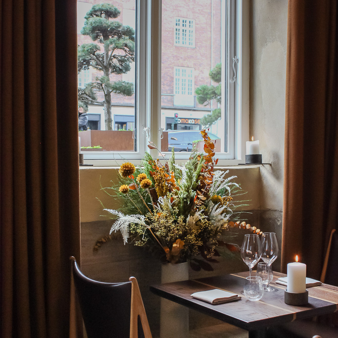 Ett vackert dukat bord på restaurang där en orange bukett får sprida ut sig