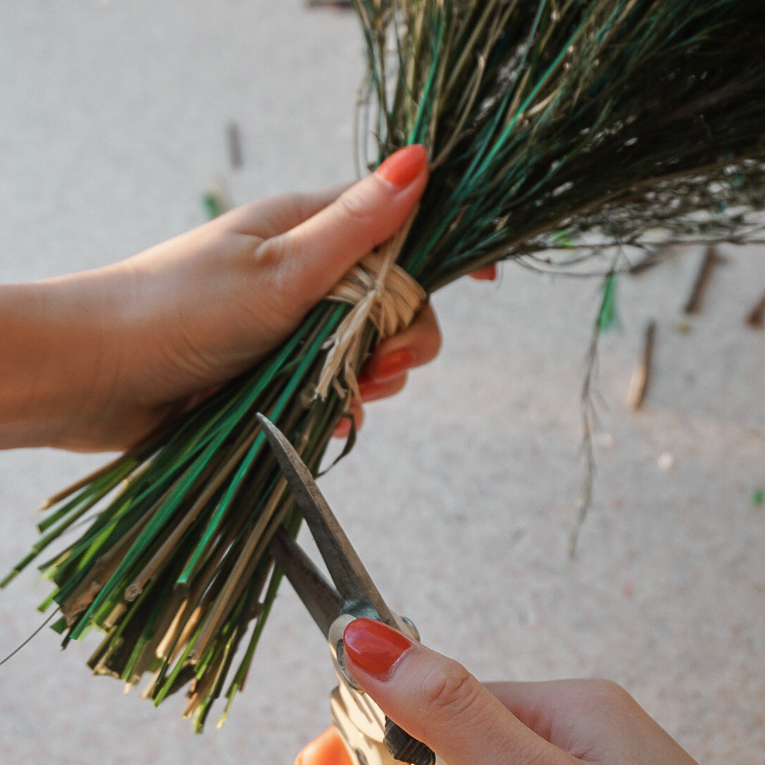 Närbild av händer som ska klippa bukettens stjälkar kortare med en sekatör