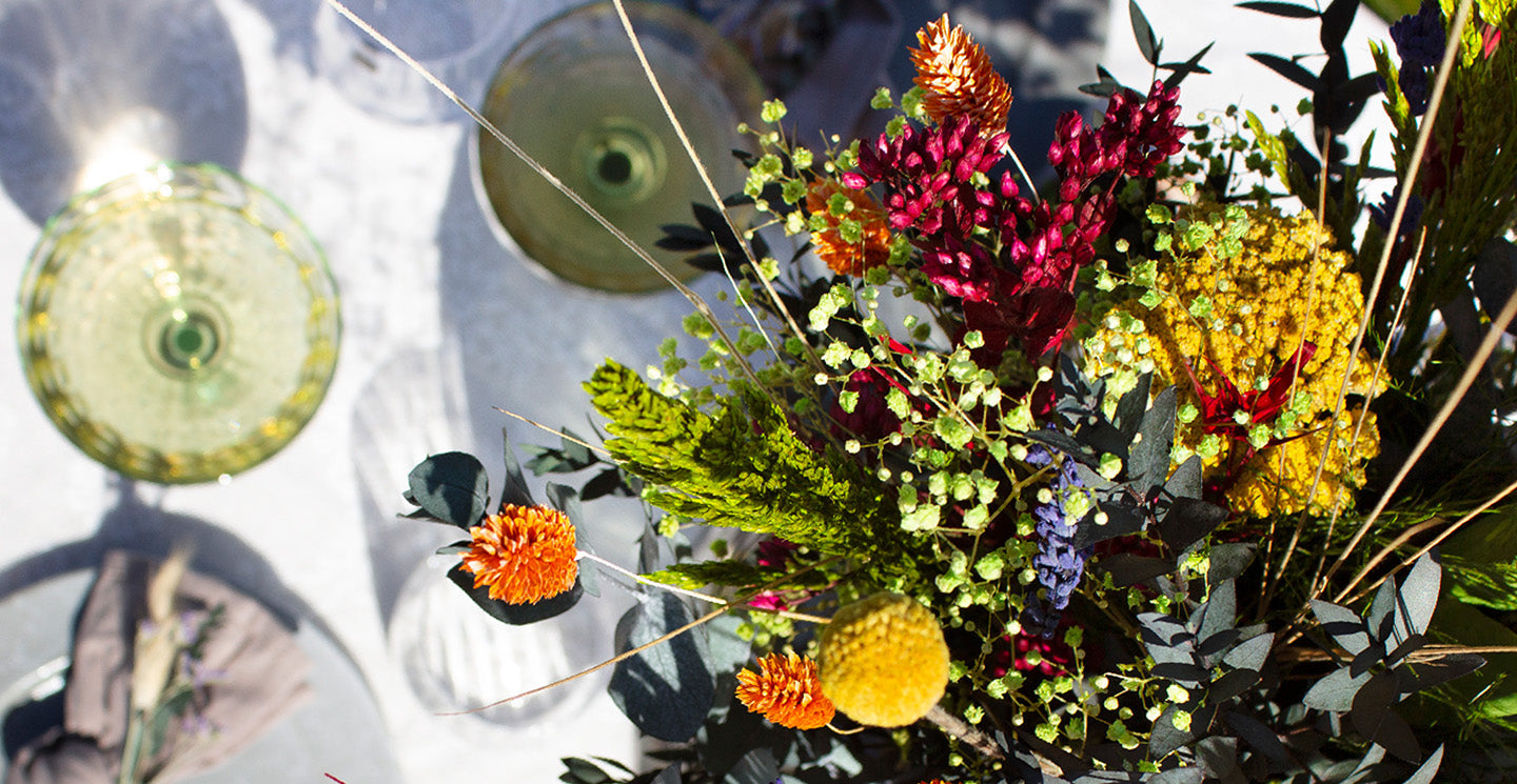 Stilfull festdukning till Midsommar sedd ovanifrån, med färgstarka blommor i buketten Blomsterglädje