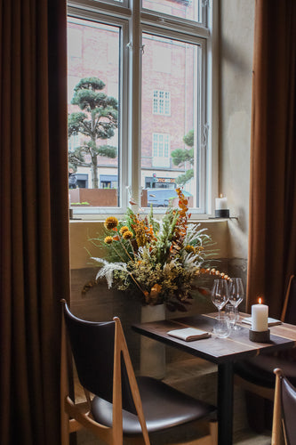 Bord, stol og blomster på restaurant