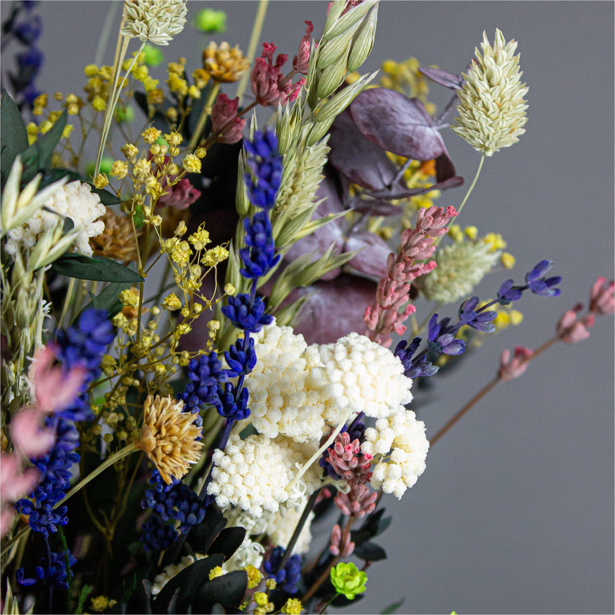 Nærbillede af en farverig blomsterbuket lavet af langtidsholdbare blomster.