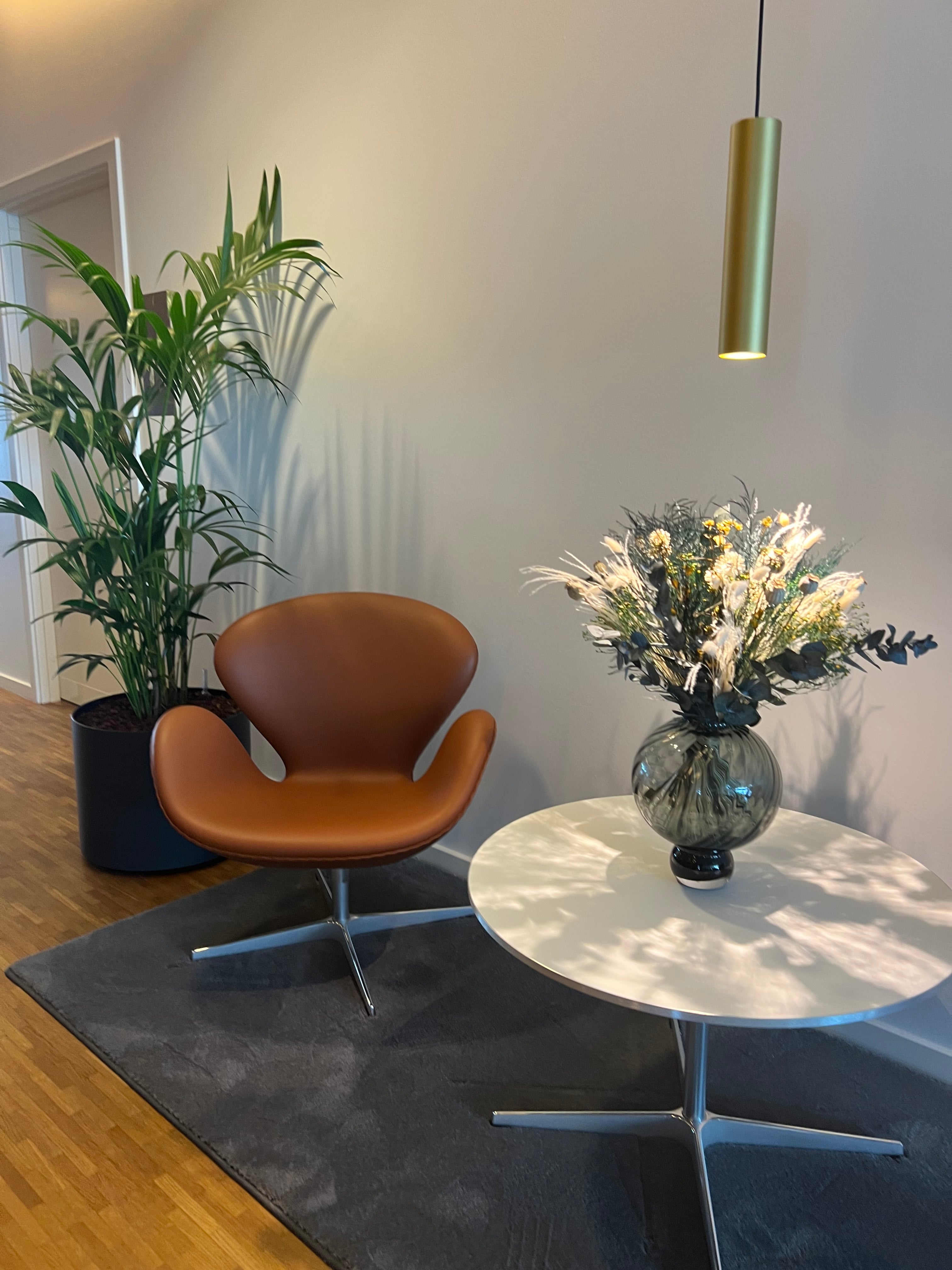 På et lille bord i et opholdsområde står en smuk buket med langtidsholdbare blomster.
